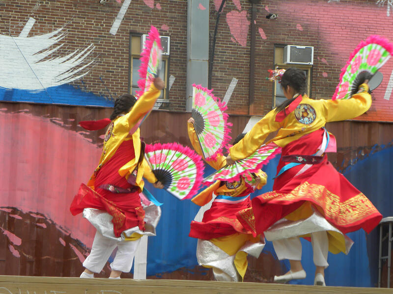 Korean fan dancers with painted wall and shipping container